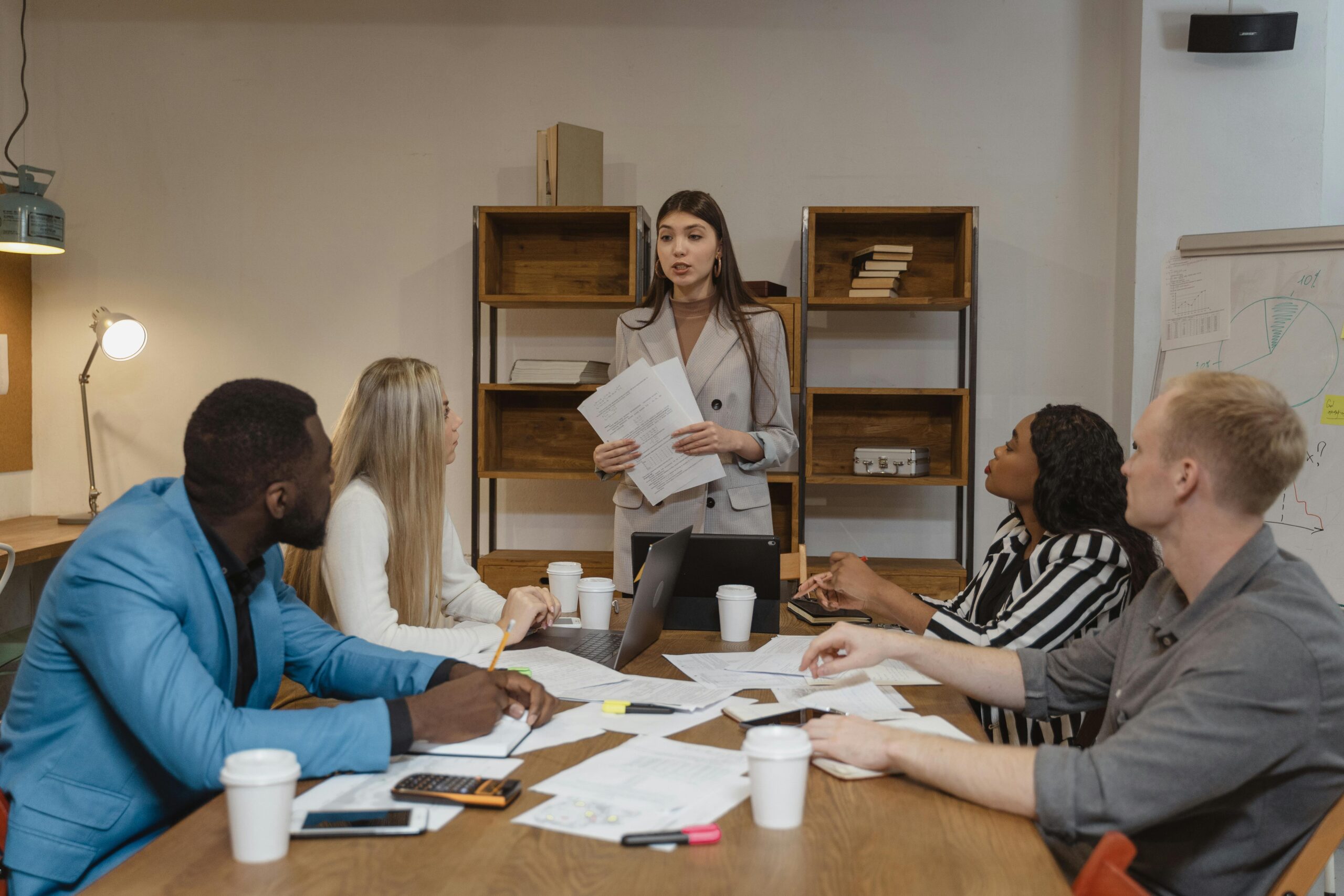Woman in a gray blazer presenting a marketing report.